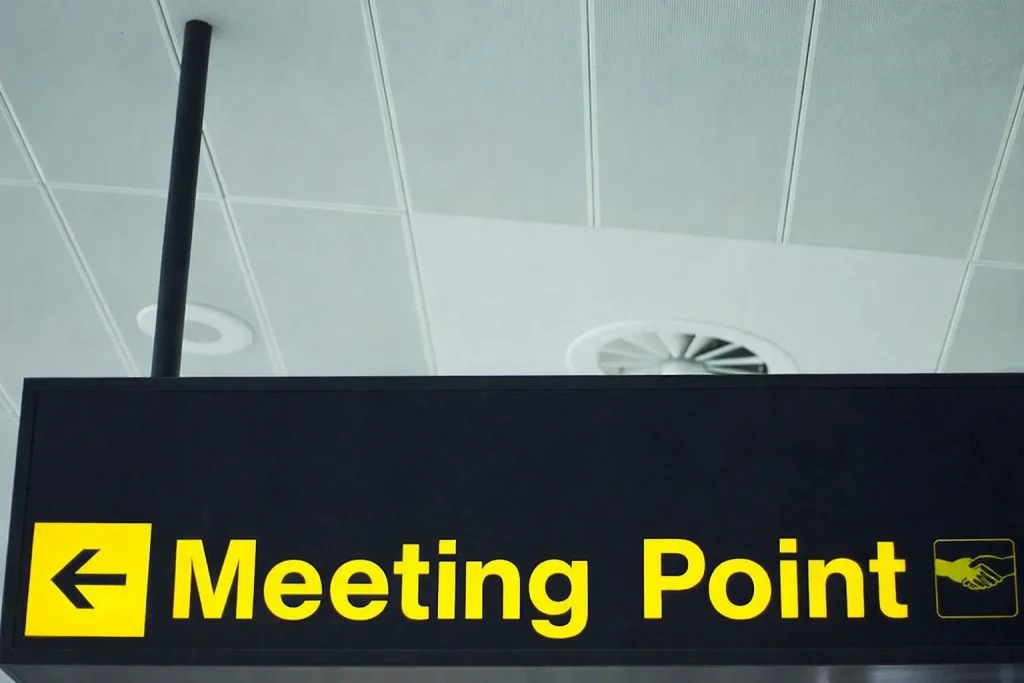 Clear text message confirming airport meet point for a corporate pickup