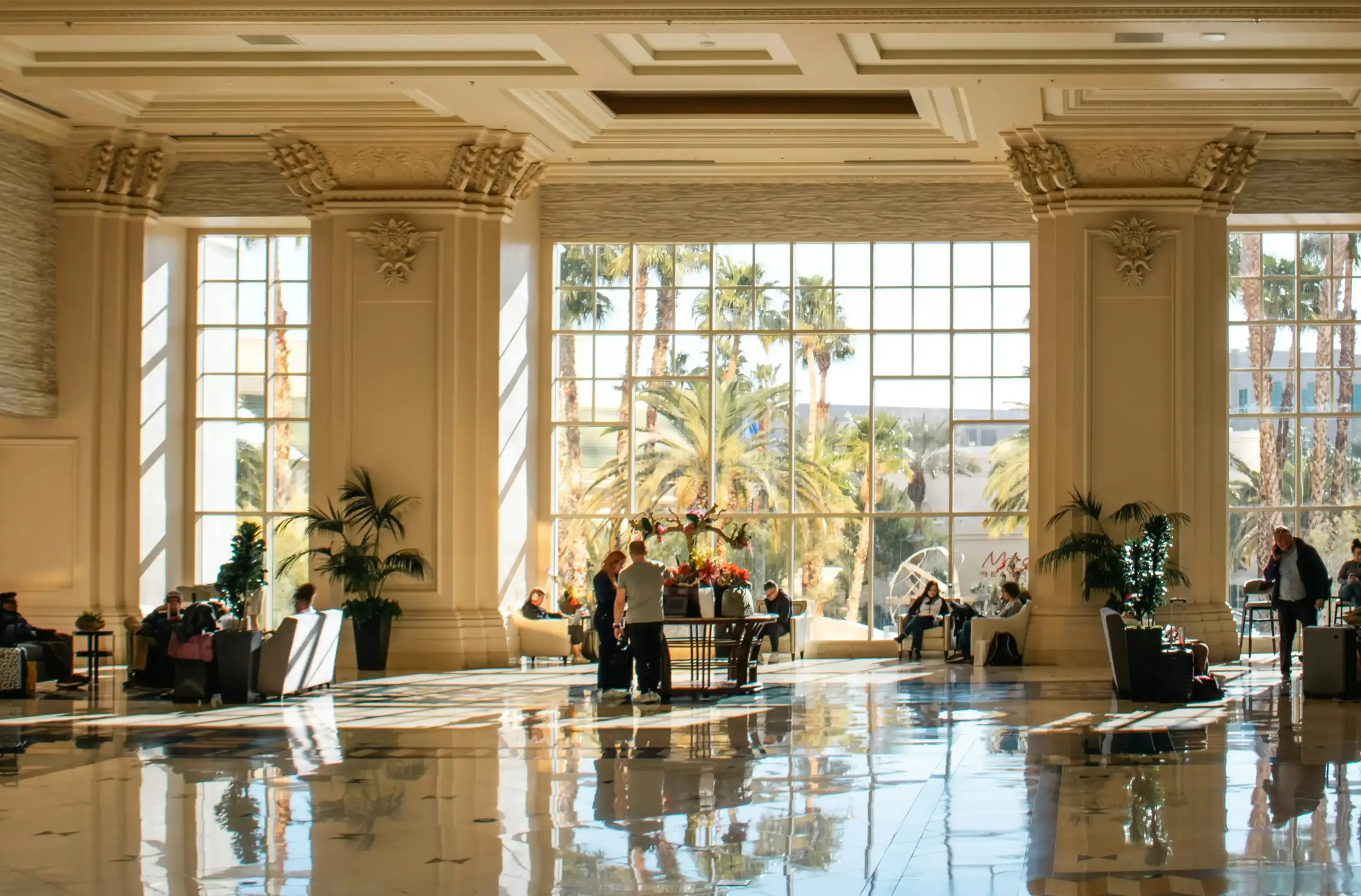 traveler reviewing chauffeur booking on smartphone beside carry-on luggage in a stylish Seattle hotel lobby, concierge desk nearby, luxury sedan visible through glass entrance