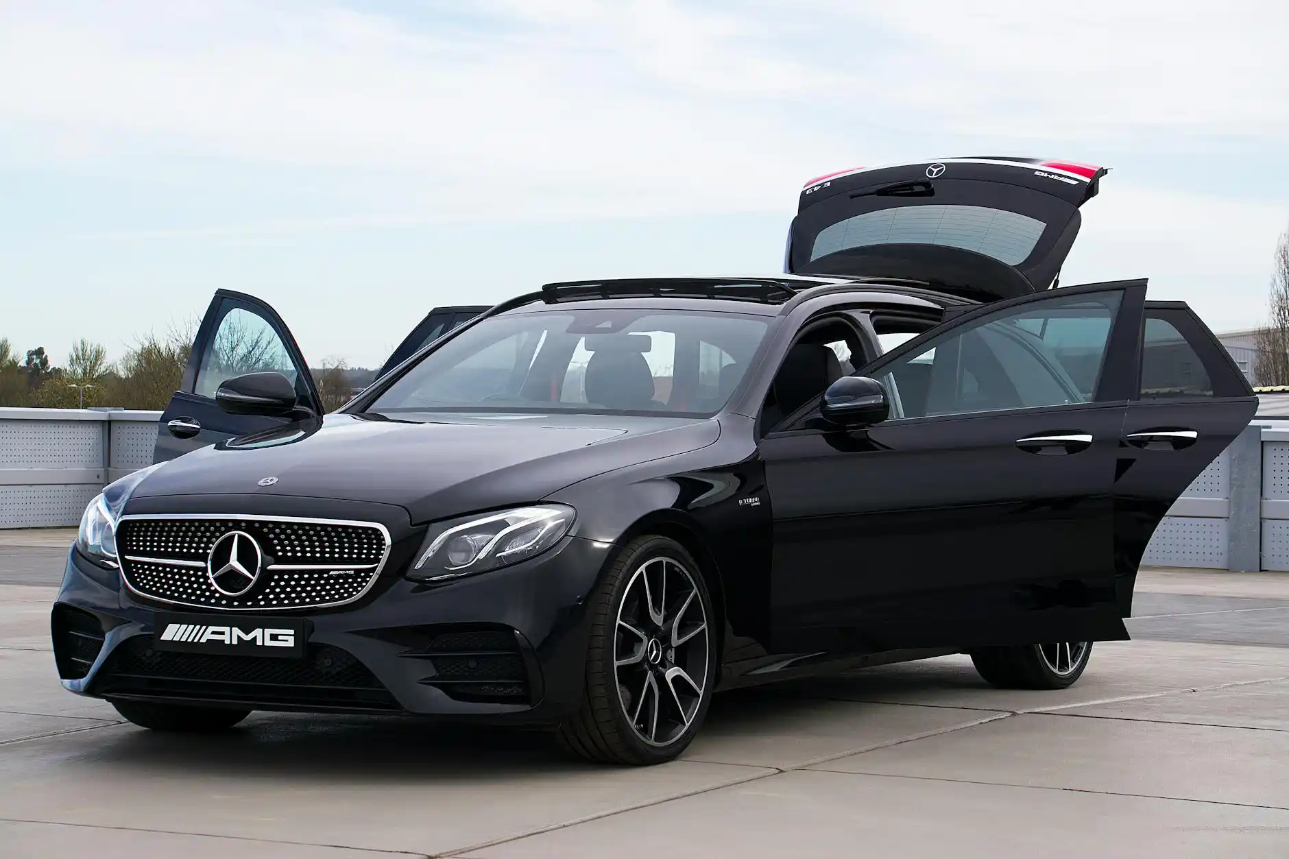 comparison scene showing luxury sedan, black SUV, and executive van lined up outside upscale Bellevue hotel entrance, open cargo areas displaying different luggage capacities wi...
