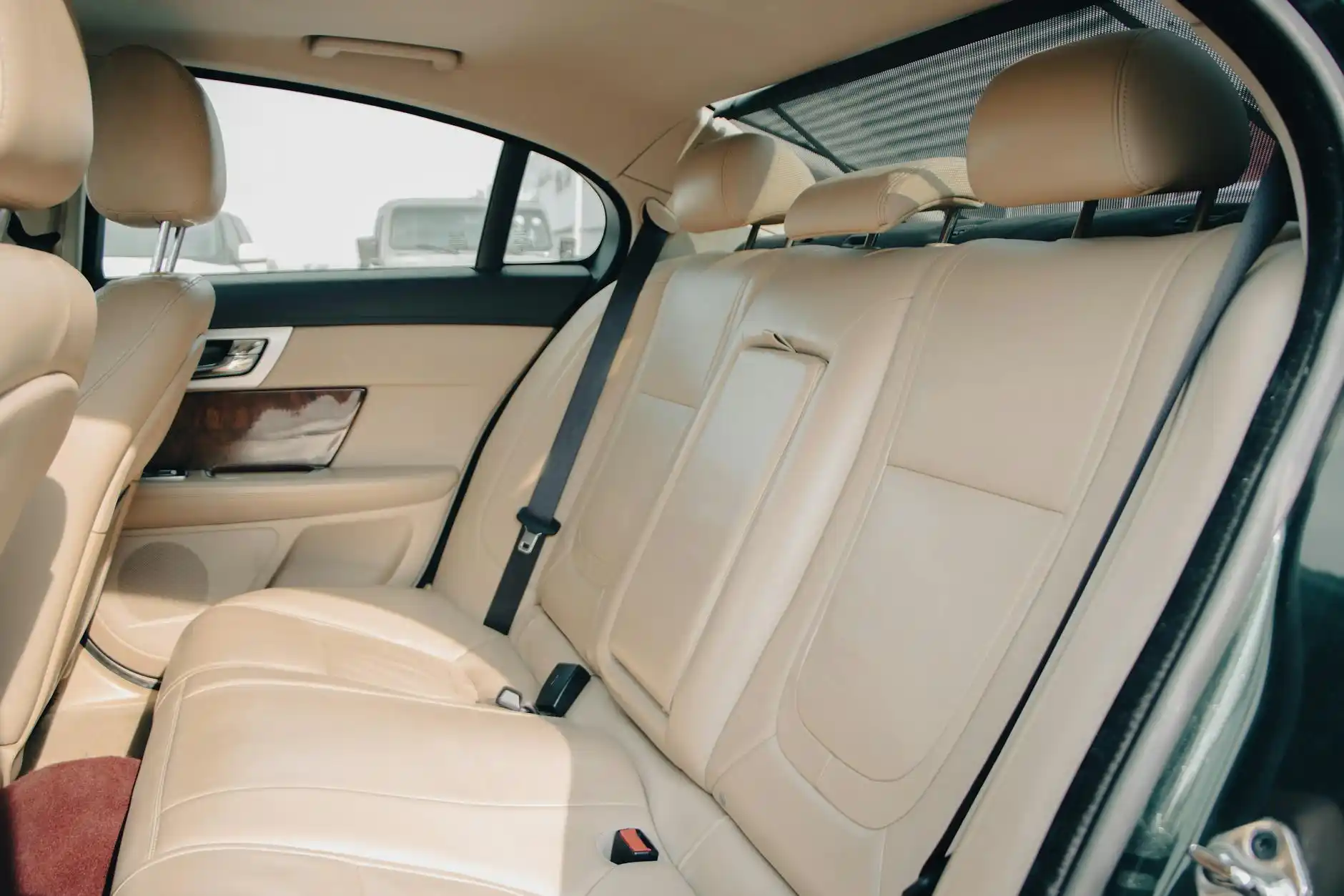 interior of a premium town car with tan leather seats, bottled water, soft ambient lighting, and a scenic view of Woodinville vineyards through the window