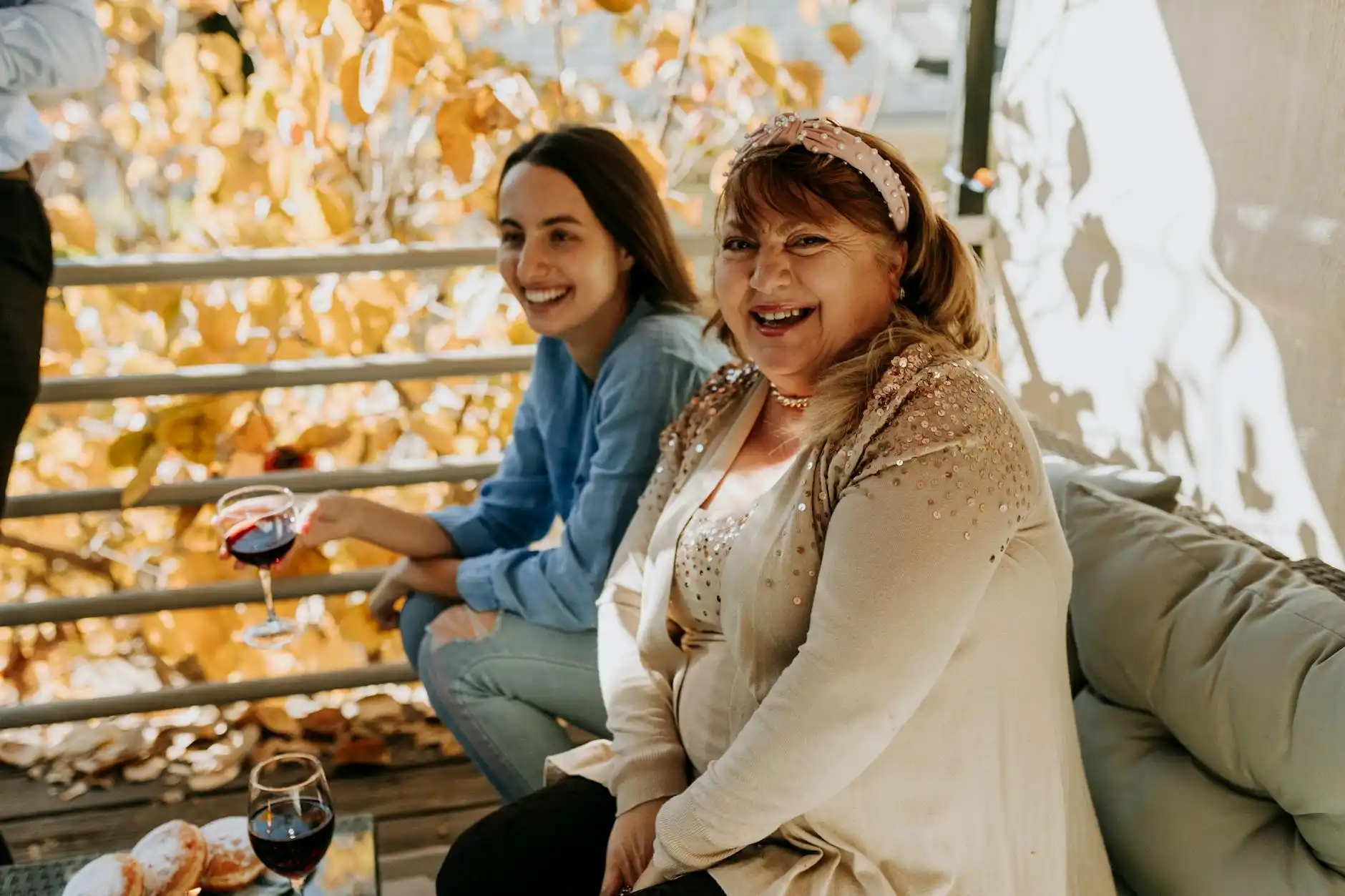 stylish group of friends seated at an outdoor Woodinville winery patio table with wine flights, artisan cheese board, autumn trees, and a chauffeur vehicle parked discreetly nearby