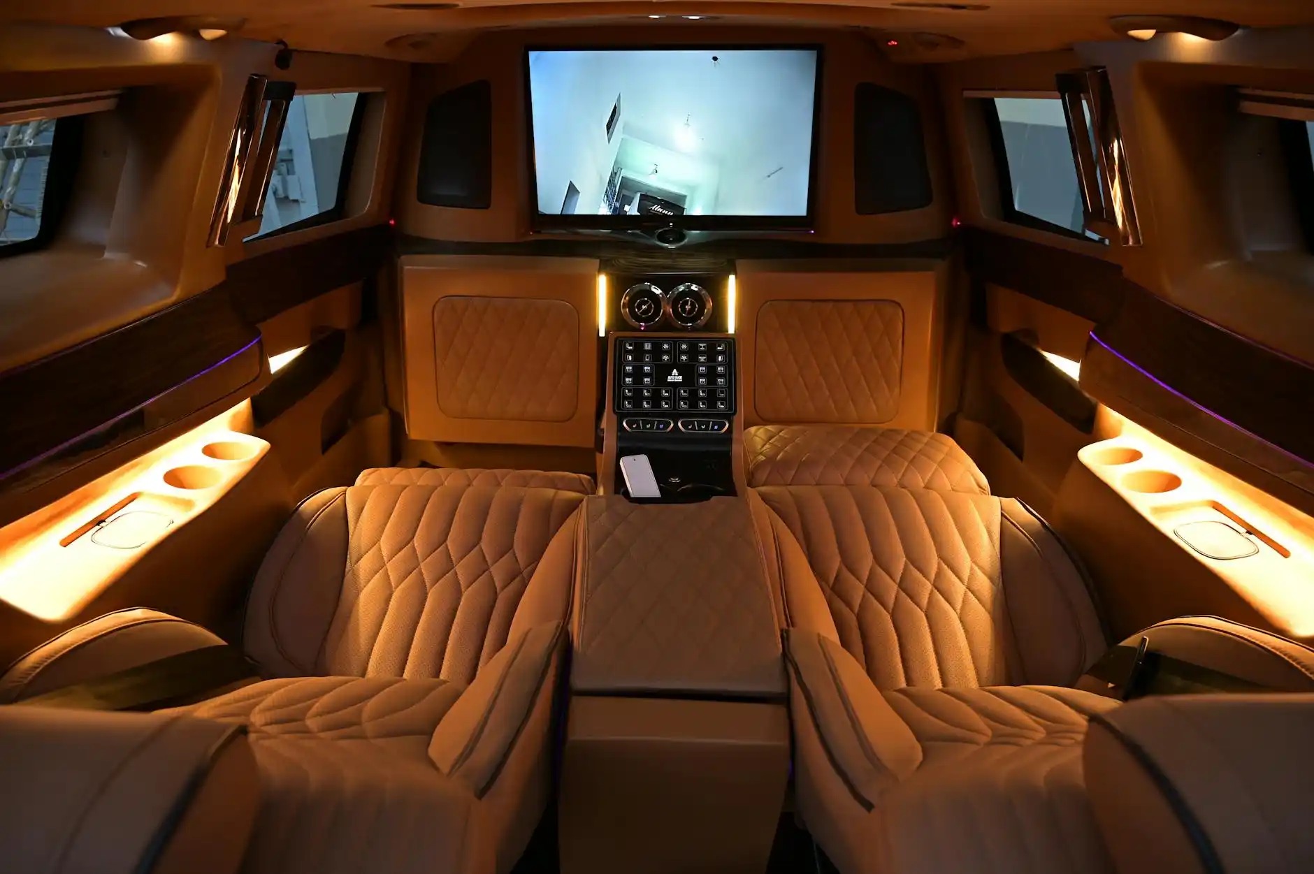 interior of a premium airport limousine with leather seating, soft ambient lighting, bottled water, smartphone charging ports, and a laptop bag on the seat, Seattle skyline fain...