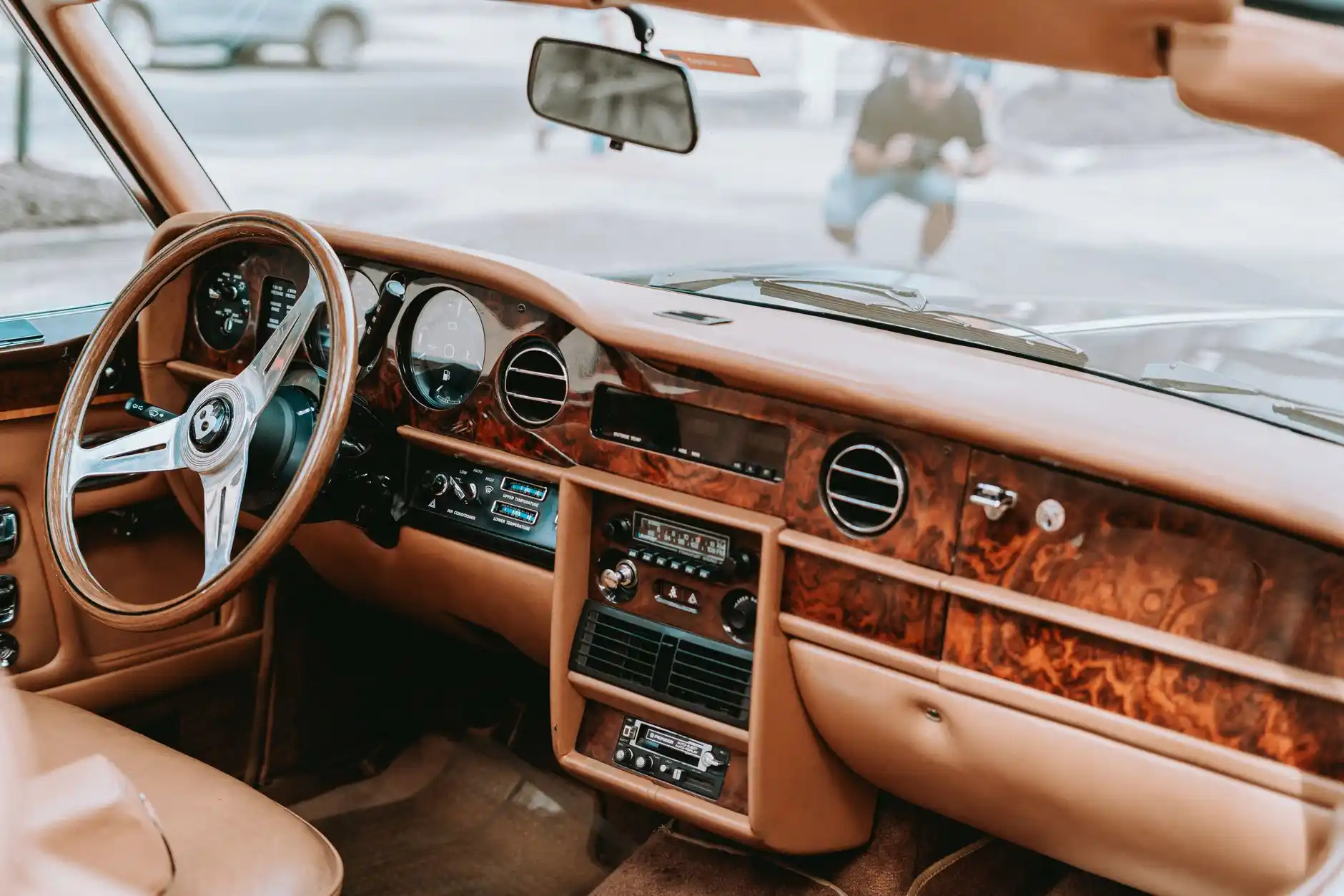 executive seated in rear cabin of a luxury sedan using a laptop, panoramic Seattle waterfront visible through tinted windows, refined leather interior with soft ambient lighting