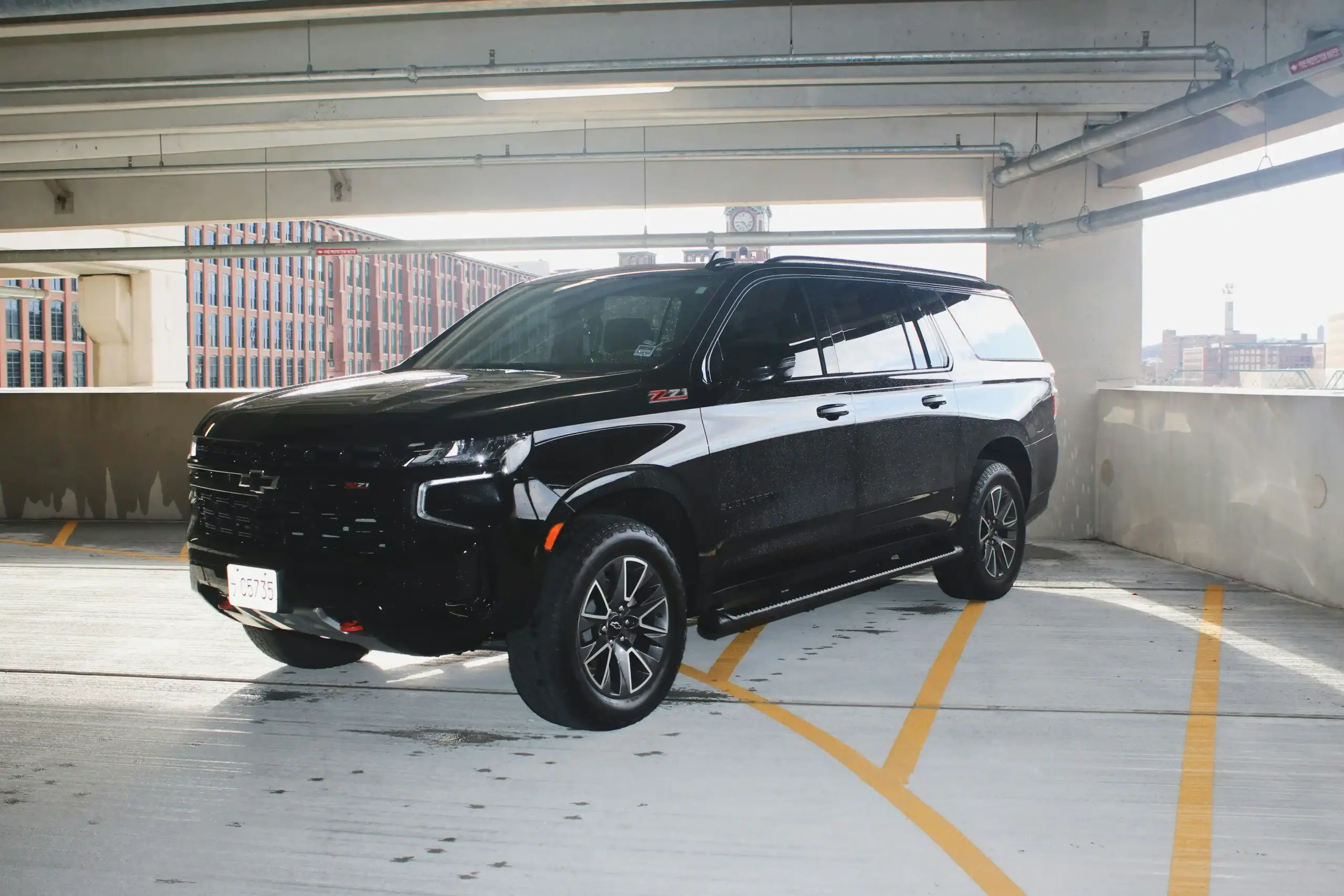 side-by-side lineup of luxury airport transfer vehicles in Seattle, black sedan, black SUV, executive van, wet pavement, urban hotel entrance, realistic premium fleet presentation