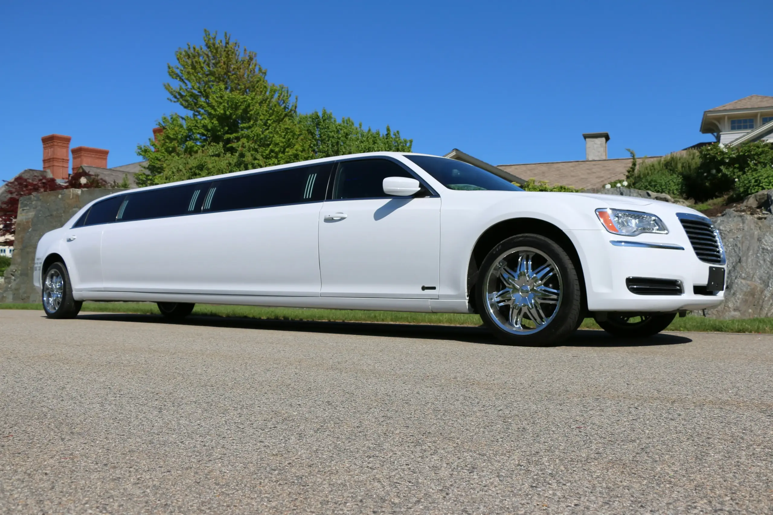 black luxury limousine arriving at Seattle-Tacoma International Airport curbside at dawn, chauffeur opening rear door, rolling suitcases nearby, terminal glass reflecting soft P...