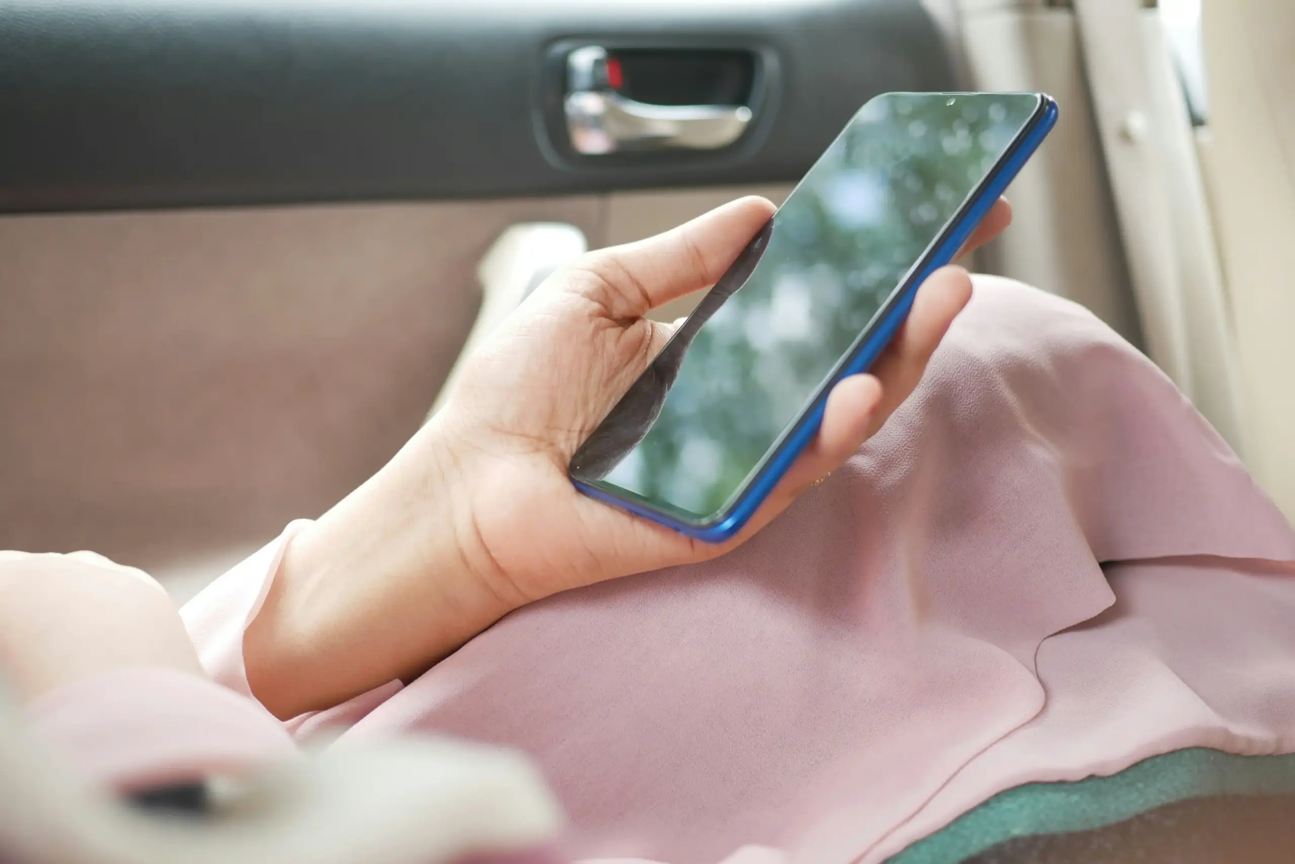 Smartphone displaying an itemized private car quote with base fare, tolls, parking, gratuity, waiting time, and final total beside a black sedan